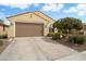 Inviting home exterior with a spacious driveway, desert landscaping, and a two-car garage at 27030 W Escuda Dr, Buckeye, AZ 85396