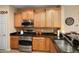Well-lit kitchen featuring stainless steel appliances, granite countertops, and light wood cabinets at 27030 W Escuda Dr, Buckeye, AZ 85396