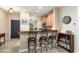 Kitchen bar with granite countertop and three chairs overlooking an adjacent dining area at 27030 W Escuda Dr, Buckeye, AZ 85396