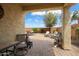 Covered patio featuring a brick-paver surface and a seating area with a tree at 27030 W Escuda Dr, Buckeye, AZ 85396