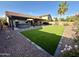 Well maintained backyard with green lawn, desert landscaping, covered patio, and outdoor hot tub at 2705 E Rock Wren Rd, Phoenix, AZ 85048