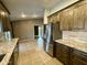 Modern kitchen with granite countertops, stainless steel refrigerator, and views into the living area at 2705 E Rock Wren Rd, Phoenix, AZ 85048