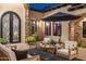 Charming courtyard with stone accents, a covered patio, and outdoor seating beneath a dark umbrella at 2782 E Citadel Ct, Gilbert, AZ 85298