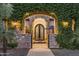 Stunning vine-covered archway leads to stone entrance and a wrought iron door under a stone arch at 2782 E Citadel Ct, Gilbert, AZ 85298