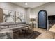 Modern living room features a large sectional sofa, artistic decor, and arched entry at 2782 E Citadel Ct, Gilbert, AZ 85298