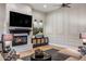 Inviting living room showcasing a stone fireplace, sleek black console, and elegant paneled wall accents at 2782 E Citadel Ct, Gilbert, AZ 85298