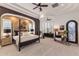 Spacious main bedroom featuring a four-poster bed, stylish decor, and plenty of natural light from large windows at 2782 E Citadel Ct, Gilbert, AZ 85298