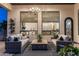 Inviting outdoor patio with comfortable seating, chandelier lighting, and views of the interior rooms through large windows at 2782 E Citadel Ct, Gilbert, AZ 85298