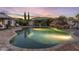 Lush backyard oasis featuring a private pool with rock waterfall and a covered lounge area, perfect for outdoor entertaining at 2782 E Citadel Ct, Gilbert, AZ 85298