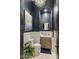 Stylish powder room featuring dark blue walls, white wainscoting, and a modern vanity with elegant fixtures at 2782 E Citadel Ct, Gilbert, AZ 85298