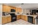 Functional kitchen with light wood cabinets, black appliances, and ample counter space for cooking at 2841 S Esmeralda Cir, Mesa, AZ 85212
