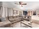 Open living room with sectional sofa, wood-look tile floors, leading into a dining area and kitchen at 2841 S Esmeralda Cir, Mesa, AZ 85212