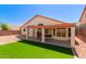 An airy back patio, complete with artificial grass and a tiled seating area, is great for entertaining at 2904 E Ludlow Dr, Phoenix, AZ 85032