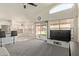 A modern living room flows with the kitchen, and features a ceiling fan and sliding doors to the yard at 2904 E Ludlow Dr, Phoenix, AZ 85032