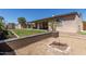 Landscaped backyard featuring a covered patio, fire pit, and well-maintained lawn at 3301 E Sharon Dr, Phoenix, AZ 85032