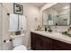 Bathroom featuring dark vanity with white countertop, decorative mirror and lighting at 3301 E Sharon Dr, Phoenix, AZ 85032