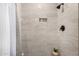 Close-up of tiled walk-in shower with built-in niche, dark fixtures, and plant detail at 3301 E Sharon Dr, Phoenix, AZ 85032