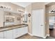 This bright bathroom features white cabinetry, double sinks with granite countertops, and a large mirror at 3443 E Thornton Ave, Gilbert, AZ 85297