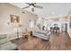 Bright living room with hardwood floors and neutral décor open to a kitchen with white cabinetry at 3443 E Thornton Ave, Gilbert, AZ 85297