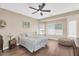 Calm bedroom features a ceiling fan, plush bedding, and natural light from two windows at 3443 E Thornton Ave, Gilbert, AZ 85297