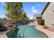 Backyard pool with rock features, desert landscape and covered patio at 3443 E Thornton Ave, Gilbert, AZ 85297