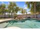 Sparkling pool featuring a serene rock waterfall and inviting turquoise water, surrounded by lush landscaping and ample sunshine at 3443 E Thornton Ave, Gilbert, AZ 85297