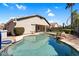 Backyard pool with rock features, desert landscape and covered patio at 3443 E Thornton Ave, Gilbert, AZ 85297