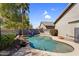 Backyard pool with rock features, desert landscape and covered patio at 3443 E Thornton Ave, Gilbert, AZ 85297