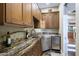 Inviting bar area with custom cabinetry, granite counters, and stainless steel mini refrigerator at 36389 N 105Th Pl, Scottsdale, AZ 85262