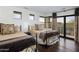 Cozy bedroom featuring two beds, wood flooring, and a balcony overlooking scenic views at 36389 N 105Th Pl, Scottsdale, AZ 85262