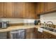 Functional kitchen with stainless steel appliances, tiled backsplash, and wooden cabinetry for all your cooking needs at 36389 N 105Th Pl, Scottsdale, AZ 85262