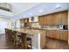 Gourmet kitchen with stone countertops, breakfast bar, stainless steel appliances, and wood cabinetry at 36389 N 105Th Pl, Scottsdale, AZ 85262