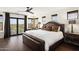 Serene primary bedroom with a large bed, wood floors, and scenic views from the windows at 36389 N 105Th Pl, Scottsdale, AZ 85262