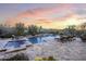 Luxurious swimming pool with cascading water feature and comfortable lounge chairs and sunset views at 36389 N 105Th Pl, Scottsdale, AZ 85262