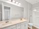 Bright bathroom featuring a double vanity with white cabinets, a mirror, and a walk-in shower at 3648 E Arabian Dr, Gilbert, AZ 85296