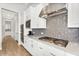 Close up of a kitchen with stainless hood, herringbone backsplash, and flat cooktop at 3648 E Arabian Dr, Gilbert, AZ 85296