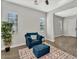 Cozy living room featuring stylish wood-look tile flooring, a comfortable armchair, and plenty of natural light at 3648 E Arabian Dr, Gilbert, AZ 85296