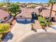 Aerial view of house featuring a three-car garage, desert landscaping, tile roof, and mature palm trees at 3841 E Redfield Ct, Gilbert, AZ 85234