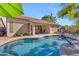 Backyard featuring a pool with a basketball hoop, covered patio, and well-maintained landscaping at 3841 E Redfield Ct, Gilbert, AZ 85234