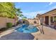 A backyard featuring a sparkling pool surrounded by lush landscaping, palm trees, and patio seating at 3841 E Redfield Ct, Gilbert, AZ 85234