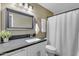 Bathroom with large framed mirror over granite countertop, toilet and shower at 3841 E Redfield Ct, Gilbert, AZ 85234