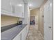 Hallway with gray countertops, white cabinetry, and tile floors leading into an office space at 3841 E Redfield Ct, Gilbert, AZ 85234