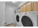 Bright laundry room features a washer and dryer, storage cabinets, and convenient access to the home's exterior at 3841 E Redfield Ct, Gilbert, AZ 85234