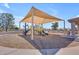 Community playground featuring covered play structure with swings, slides, and a bench on a sunny day at 3841 E Redfield Ct, Gilbert, AZ 85234