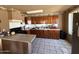 Functional kitchen featuring wood cabinets, peninsula breakfast bar and tile floors at 3937 W Stella Ln, Phoenix, AZ 85019