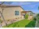 Exterior view of home showcasing lush backyard with manicured lawn and covered patio at 4027 W Copperleaf Dr, San Tan Valley, AZ 85144