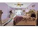 Bright bedroom featuring floral accents, decorative furnishings, ceiling fan, and large window at 4027 W Copperleaf Dr, San Tan Valley, AZ 85144