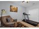 Home exercise area featuring a treadmill, comfortable chair, and stylish decor at 4027 W Copperleaf Dr, San Tan Valley, AZ 85144