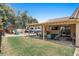 Backyard patio offers a covered seating area with a TV, grill, and view of the playset and RV parking at 421 E Terrace Ave, Gilbert, AZ 85234