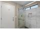 Shower with sliding glass door and marble wall tiles, adjacent to the entry door at 421 E Terrace Ave, Gilbert, AZ 85234